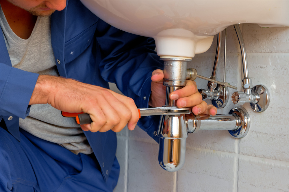 A plumber at work in a bathroom